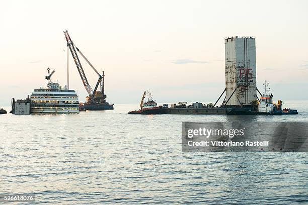 Floating crane carries the last water tank to be put on one side of the Italian cruiser Costa Concordia June 28, 2014. The Concordia ran aground the...