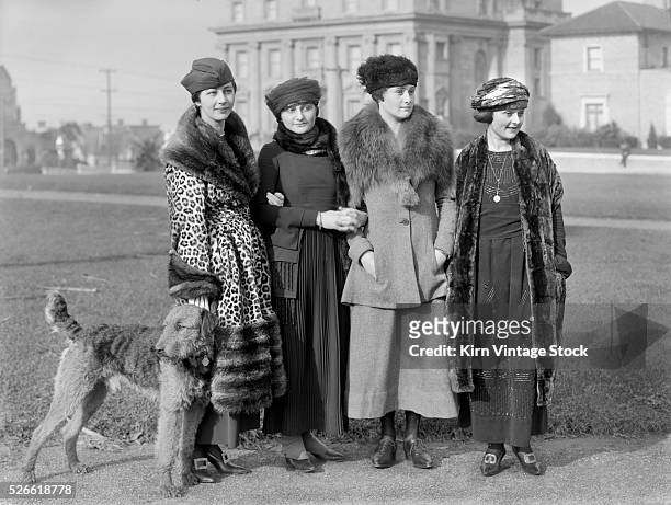 Four young women dressed in the high fashion of the day pose in San Francisco.