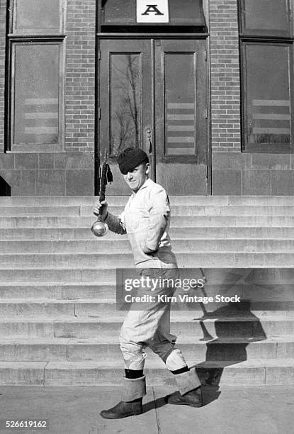 Naval drum major practices his moves with his mace on the grounds of Great Lakes Naval Training Station.