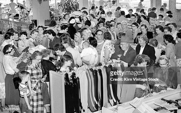 Throng of shoppers crowd a newly-opened department store in search of deals in 1950s Chicago.