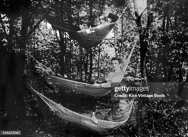 Three young men in hammocks in the woods, ca. 1930.