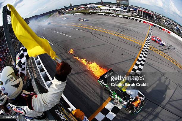 Blake Koch, driver of the LeafFilter Gutter Protection Chevrolet, crosses the finish line in flames after the NASCAR XFINITY Series Sparks Energy 300...