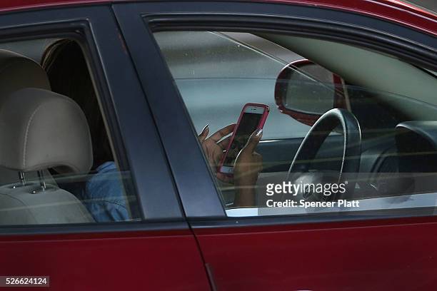 Driver uses a phone while behind the wheel of a car on April 30, 2016 in New York City. As accidents involving drivers using phones or other personal...