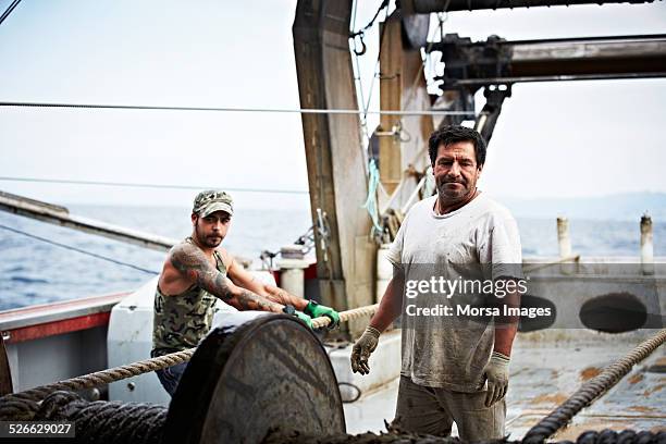 fishermen on fishing trawler - tee reel stock pictures, royalty-free photos & images