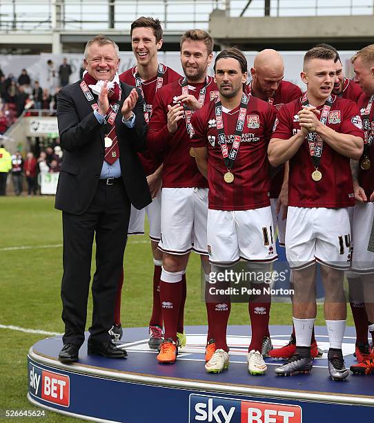 Northampton Town manager Chris Wilder with his players Luke Prosser, Joel Byrom, Ricky Holmes and Sam Hoskins look on after receiving there medals...