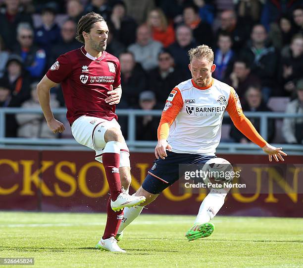 Ricky Holmes of Northampton Town plays the ball watched by Danny Green of Luton Town during the Sky Bet League Two match between Northampton Town and...