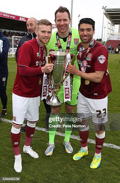 Alfie Potter Ryan Clarke and Danny Rose of Northampton Town celebrate with the Sky Bet League Two champions trophy after the Sky Bet League Two match...