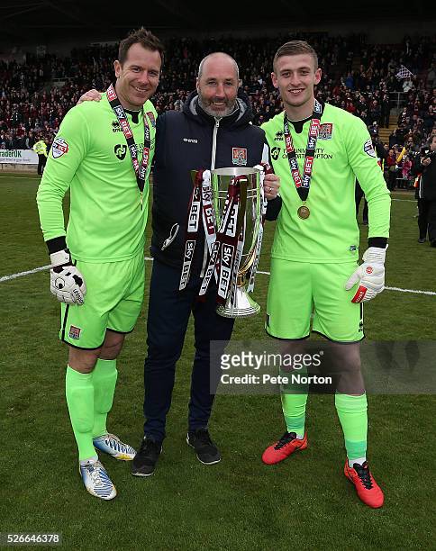 Ryan Clarke Carl Muggleton and Adam Smith of Northampton Town celebrate with the Sky Bet League Two champions trophy after the Sky Bet League Two...