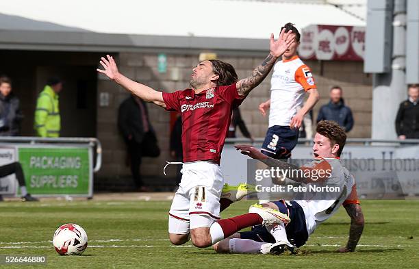 Ricky Holmes of Northampton Town goes to ground under the challenge of Glen Rea of Luton Town during the Sky Bet League Two match between Northampton...