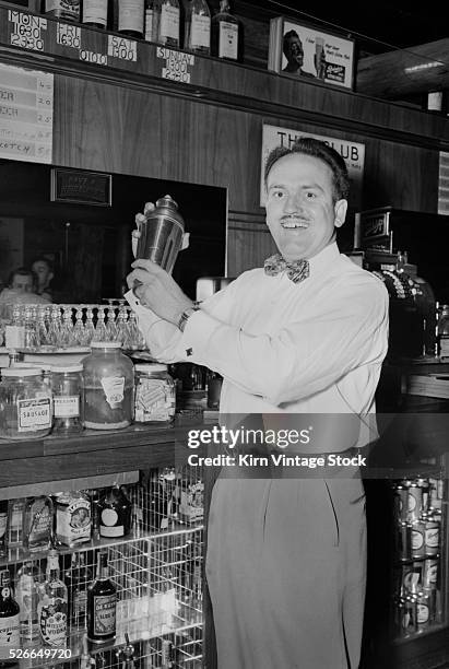 Bartender uses a shaker to make a mixed drink in a post-World War II Maryland tavern.