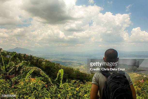 backpacker looking over distant clouds - tagaytay stock pictures, royalty-free photos & images