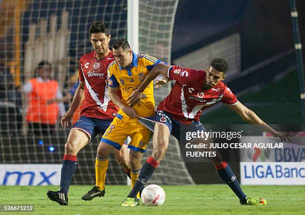 Israel Jimenez of Tigres vies for the ball with Horacio Cervantes and Carlos Calvo of Veracruz during their Mexican Clausura 2016 tournament football...