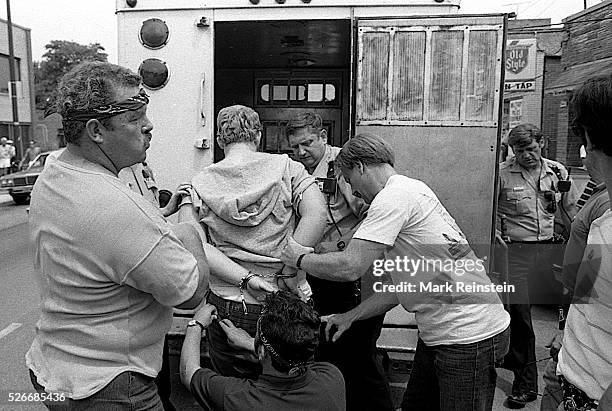 Chicago, Illinois 6-28-1986 Members of the Chicago police tactical squad arrest man in bar and then take him to paddy wagon during KKK rally in the...