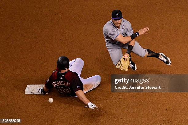 Trevor Story of the Colorado Rockies turns the double play over the sliding Paul Goldschmidt of the Arizona Diamondbacks in the fourth inning at...