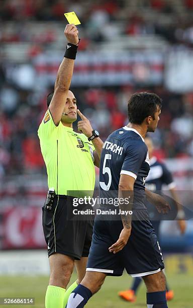 Referee Fernando Espinoza issues a yellow card to Fabian Cubero, of Velez Sarsfield, during a match between River Plate and Velez Sarsfield as part...
