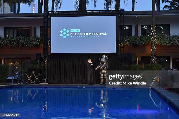Image was shot in HDR.) LOS ANGELES, CA Actor Greg Proops and Robby the Robot speak onstage at 'Forbidden Planet' screening during day 3 of the TCM...