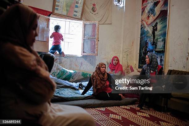 Palestinian family who recently fled fighting in Yarmouk Camp in Syria, sit inside their new home in Bourj al Barajneh Palestinian refugee camp in...