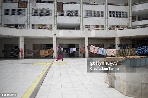 Syrian refugee crosses the ground floor of the Al Waha Commercial Centre, an abandoned shopping center in Dede Al Koura near the city of Tripoli in...