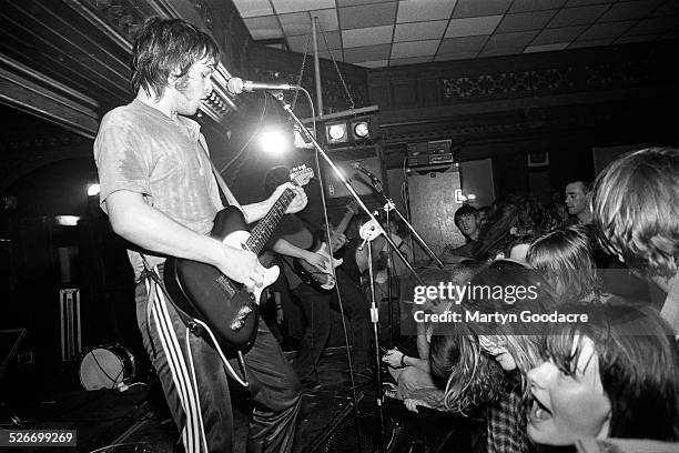 Gaz Coombes of Supergrass performs on stage, showing Britpop fans reaching out from the front rows of the audience, at Moles Club, Bath, United...