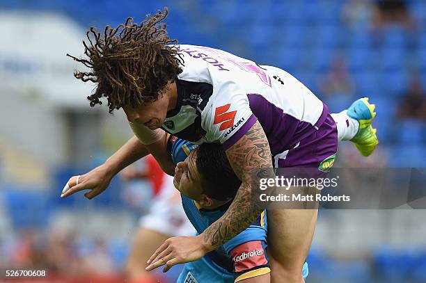 Ash Taylor of the Titans is tackled after kick the ball by Kevin Proctor of the Storm during the round nine NRL match between the Gold Coast Titans...