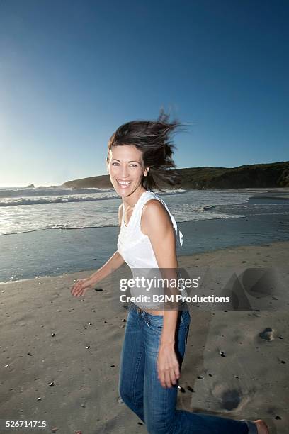 happy young woman on beach - tossing hair facing camera woman outdoors stock pictures, royalty-free photos & images