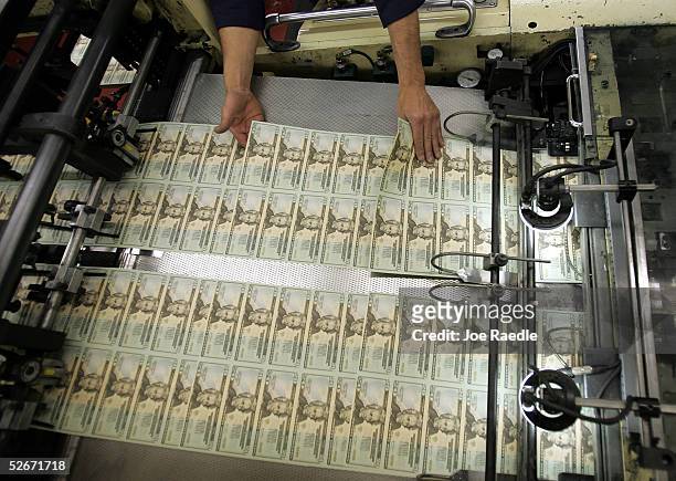 Worker looks for defective bills in the sheets of newly printed twenty dollar bills as they are prepared for distribution to financial institutions...