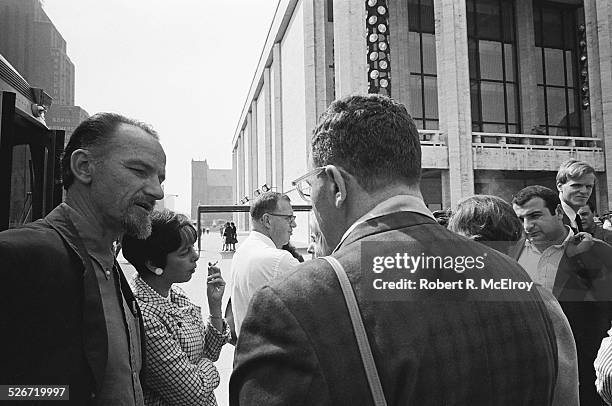 Filmmaker Ed Emshwiller, left, and independent filmmaker Shirley Clarke, with cigarette, speak to other members and attendees of the New York Film...