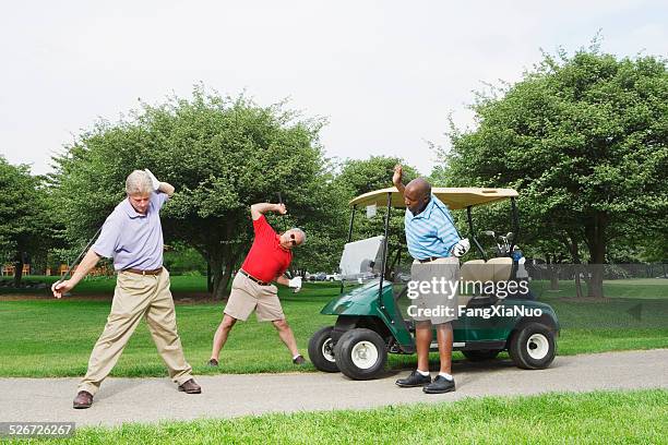 three golfers doing body exercise with golf club - senior men golf stock pictures, royalty-free photos & images