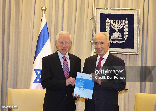 Professor Stanley Fischer, Governor of the Bank of Israel posing for photos with President Shimon Peres both are holding the 2012 Bank of Israel...