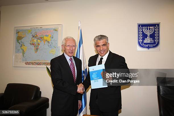 Professor Stanley Fischer, Governor of the Bank of Israel shaking hands and posing for photos with Finance Minister Yair Lapid who is holding the...