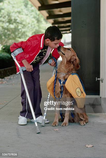 Golden retriever assistance dog licks the face of his owner Andrew Cosell a young boy with cerebal palsy.