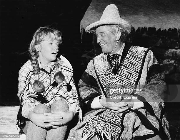 Actors Hayley Mills and Maurice Chevalier in costume, chatting on the set of the film 'In Search of the Castaways', Pinewood Studios, London, August...