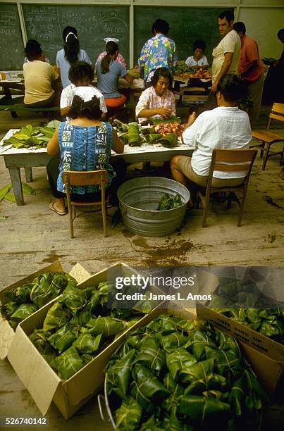 People make lau-laus, which are beef and pork wrapped in taro tops & ti leaves, for a luau to celebrate road improvements. Milolii, Hawai | Location:...