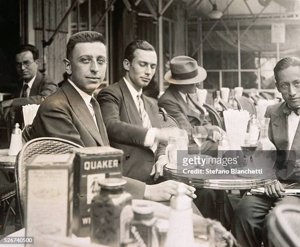 French Surrealist poet Robert Desnos sits at a table on a cafe terrace. | Located in: Bibliotheque d'Art et d'Archeologie, Fondation Jacques Doucet,...