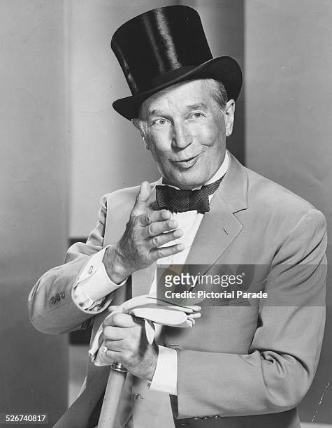Actor and cabaret star Maurice Chevalier wearing a top hat and bowtie, as he appears in the film 'Gigi', 1958.