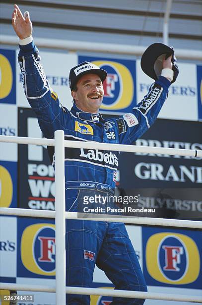 Nigel Mansell of Great Britain, driver of the Canon Williams Renault Williams FW14 Renault RS3C V10 celebrates winning the British Grand Prix on 14th...
