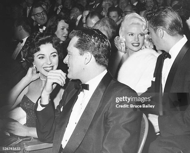 Hotel heir Nicky Hilton and actress Joan Collins sitting together at a the premiere of the film 'Heaven Knows, Mr Allison', with Jayne Mansfield and...