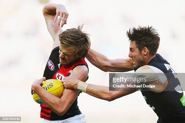 Dale Thomas of the Blues tackles Martin Gleeson of the Bombers during the round six AFL match between the Carlton Blues and the Essendon Bombers at...