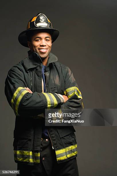 fireman smiling, on black background, portrait - black helmet stock pictures, royalty-free photos & images