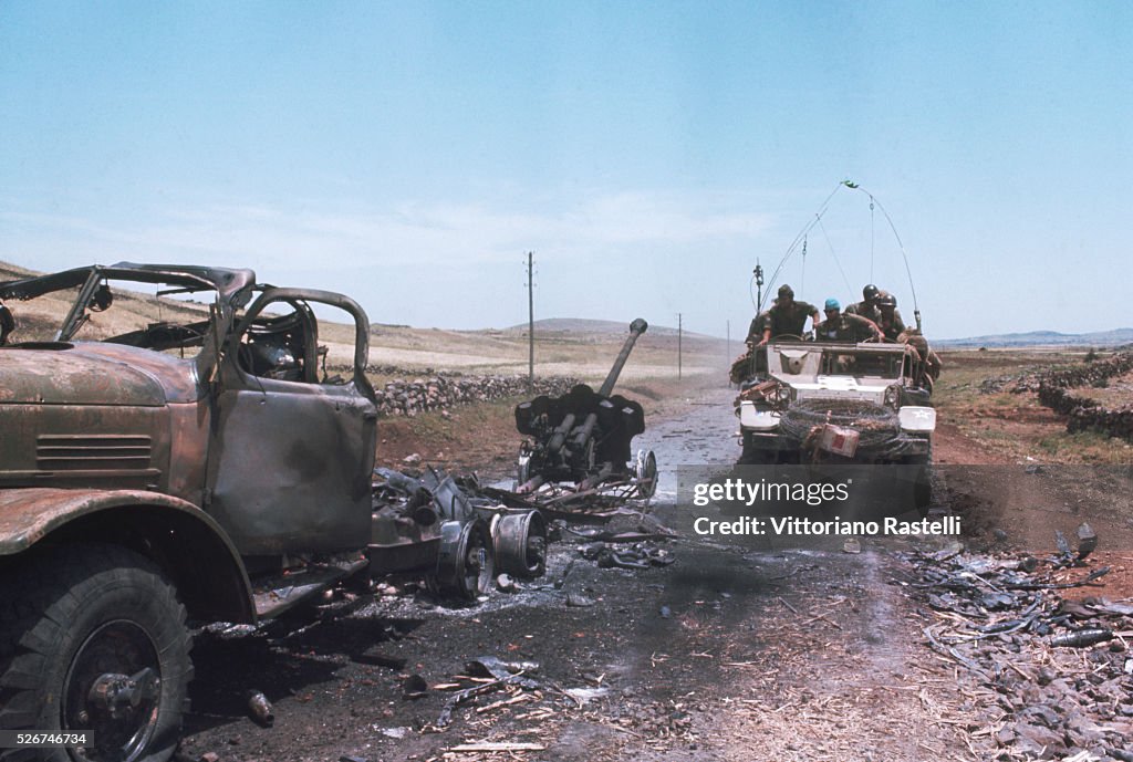 Military Vehicle Passes Wreckage