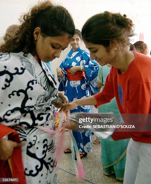 Indian college students practice the art iof tying a summer cotton Kimono 'Yukata' during a 'Indian Japan Initiative' at the SNDT University in...
