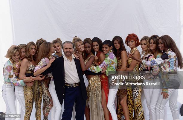 Gianni Versace poses with a group of models wearing his spring-summer collection in Milan, March 1991.