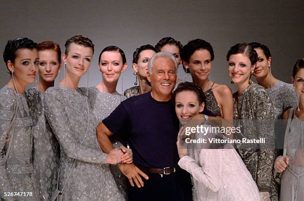 Giorgio Armani pases for photographs with a group of models in Milan, Italy.