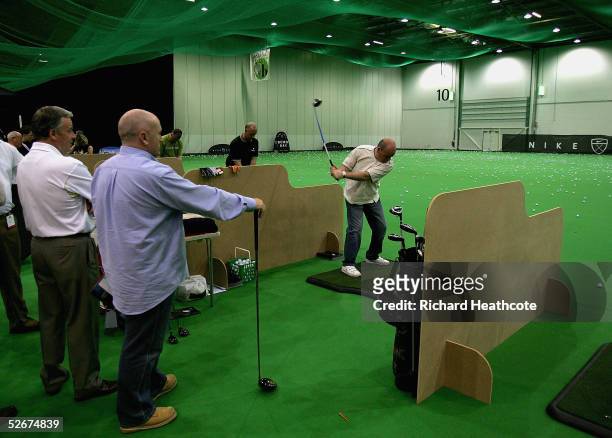 Visitors try out clubs on the indoor driving range during the London Golf Show at the London ExCeL Arena on April 21, 2005 in London, England.