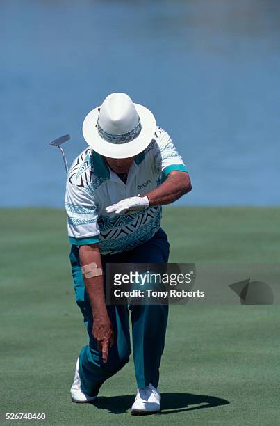 Chi Chi Rodriguez pretends to sheathe his putter after sinking a shot.