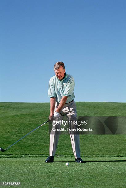 Player Al Geiberger swings at a golf ball on a golf course in Palm Desert.