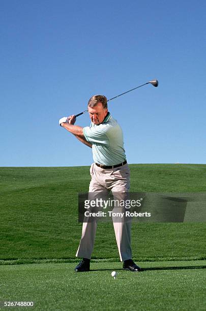 Player Al Geiberger swings at a golf ball on a golf course in Palm Desert.