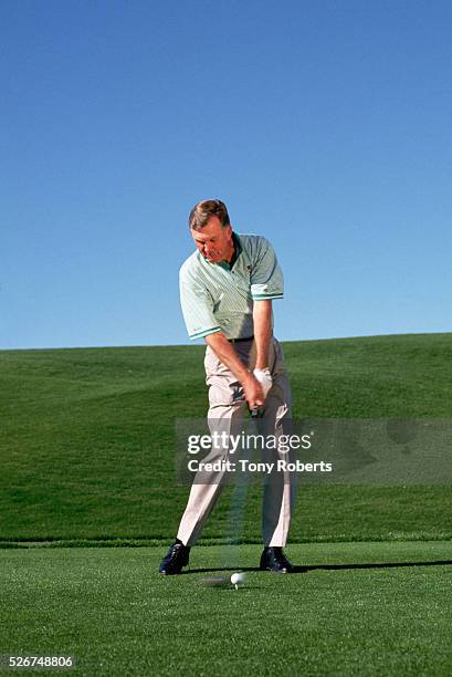 Player Al Geiberger swings at a golf ball on a golf course in Palm Desert.