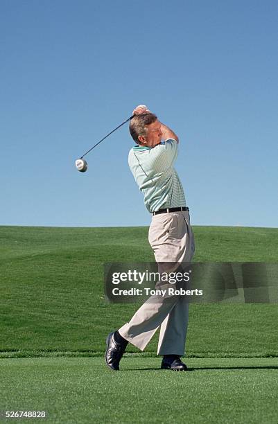 Player Al Geiberger swings at a golf ball on a golf course in Palm Desert.