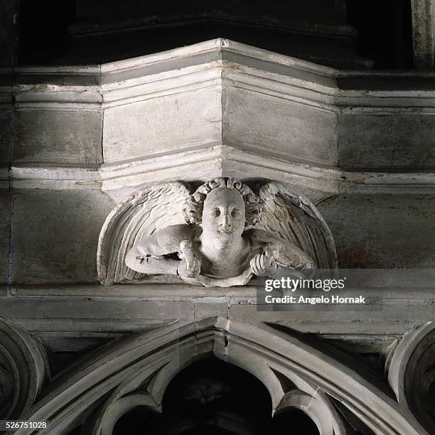 An angel looks down upon an opening in the Neville Screen which separates the altar from the tomb of Saint Cuthbert, in Durham Cathedral. The screen...